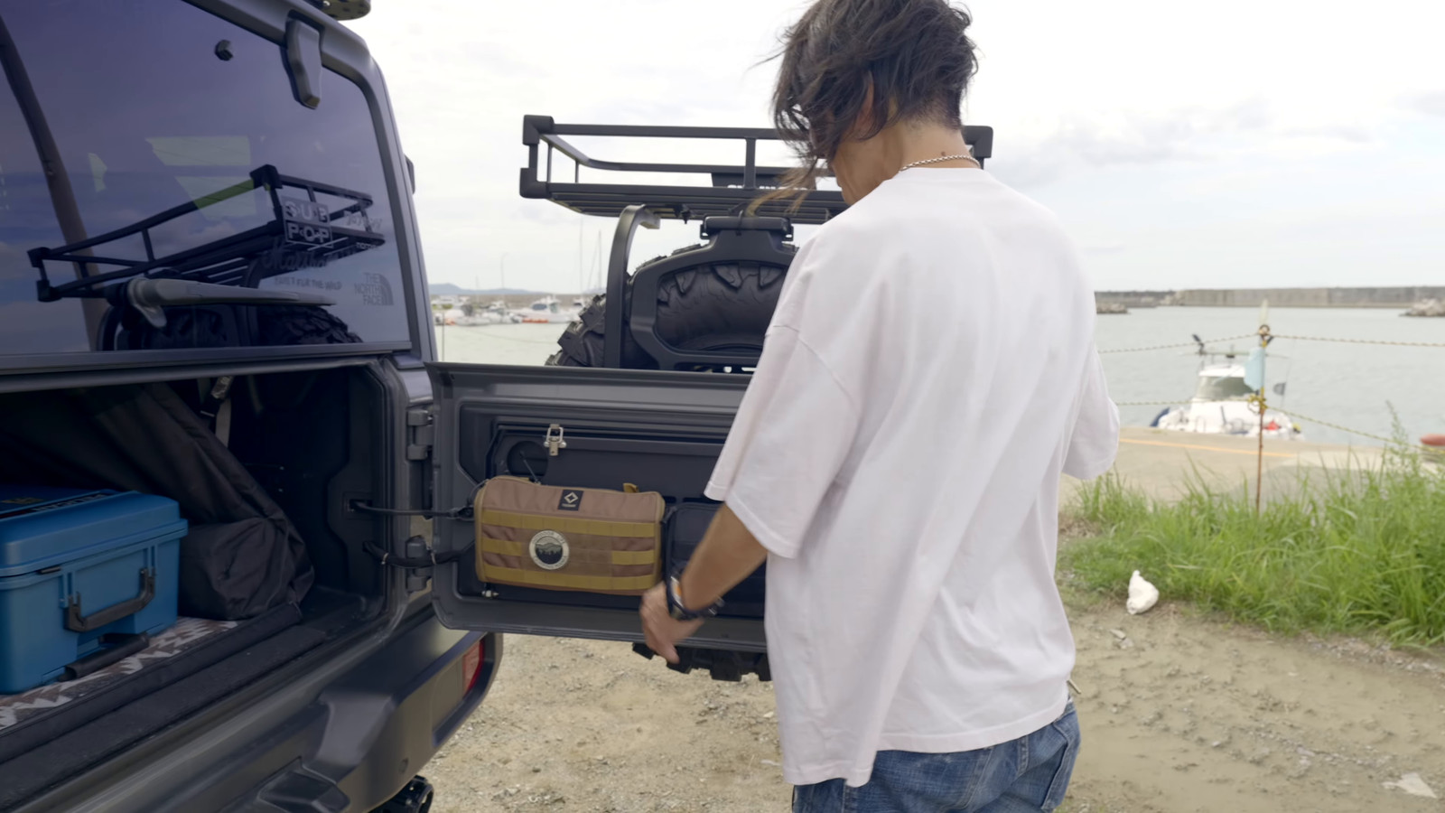 リアゲートの折りたたみテーブルを開くYoheiさんと、その左にある荷室