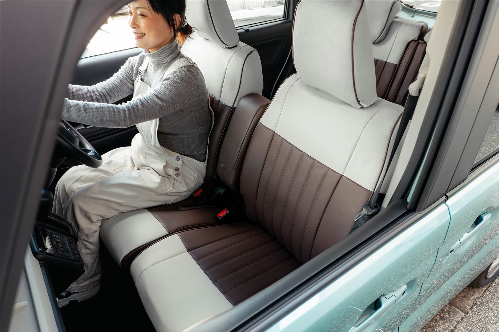 ビターショコラとスノーホワイトのマカロンを装着したスペーシアの運転席に座る人物と、助手席の全体
